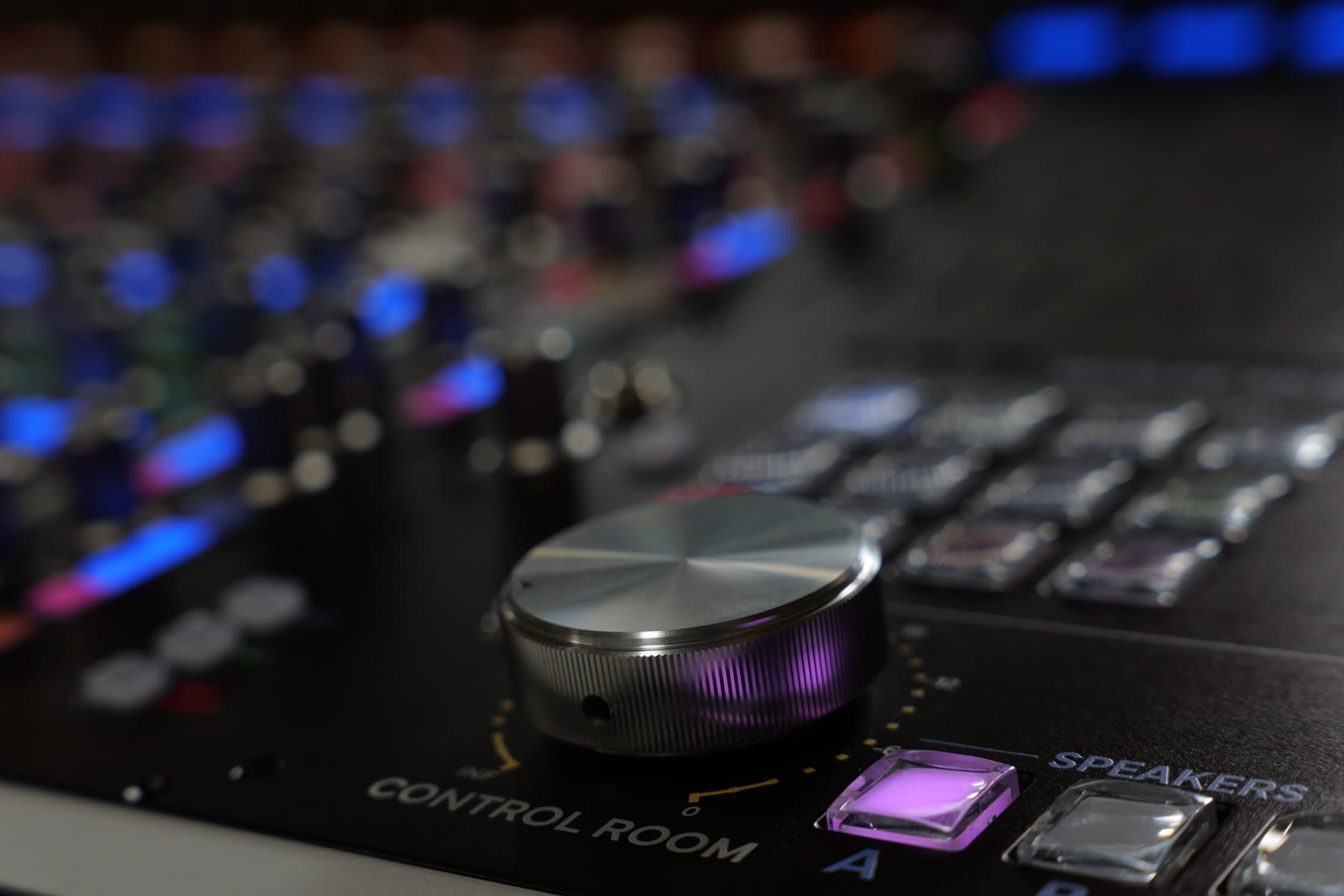 Close view of the Wolff Monitor ST level knob beside an illuminated speaker button.